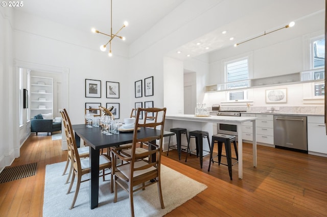 1720 NW Hoyt St, Portland, OR 97209 - dining area featuring healthy amount of natural light, light wood-style floors, a chandelier, and a towering ceiling