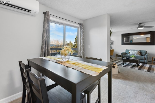 dining area featuring ceiling fan, carpet flooring, a textured ceiling, and an AC wall unit