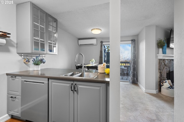 kitchen with sink, a textured ceiling, stainless steel dishwasher, and a wall mounted AC