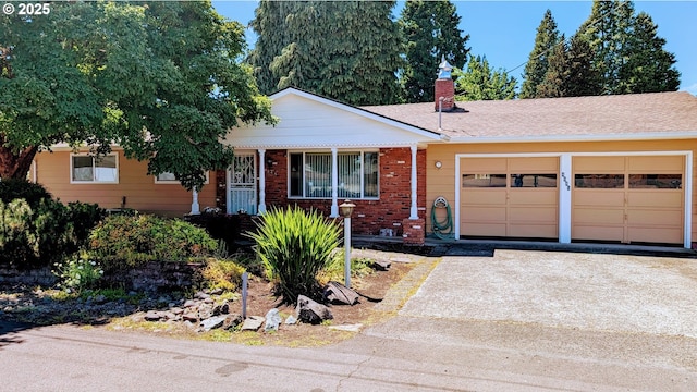 4845 Elizabeth St N, Keizer, OR 97303 - ranch-style home featuring an attached garage, driveway, brick siding, a chimney, and a porch