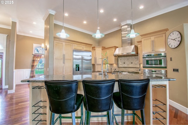34103 Adler Ln, Creswell, OR 97426 - kitchen with appliances with stainless steel finishes, wall chimney range hood, light brown cabinetry, wood finished floors, and backsplash