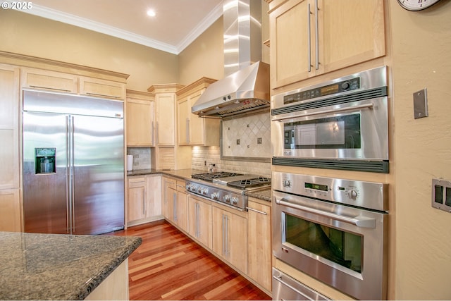 34103 Adler Ln, Creswell, OR 97426 - kitchen featuring stainless steel appliances, wall chimney exhaust hood, light brown cabinets, ornamental molding, and light wood-style floors