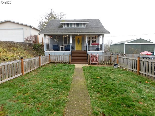 bungalow-style home with a front yard and covered porch