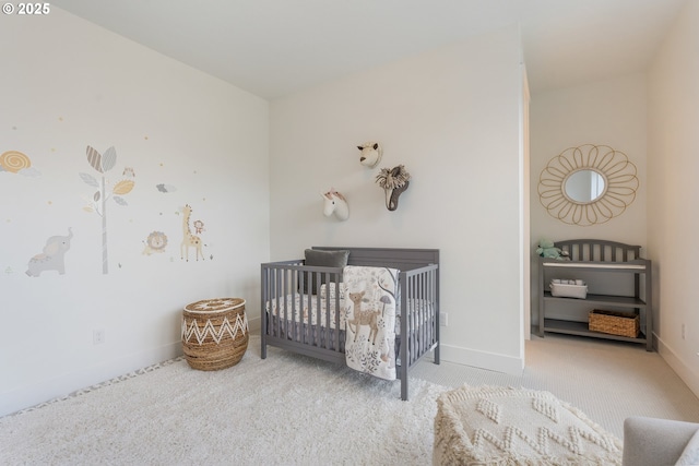 bedroom with a nursery area and light colored carpet