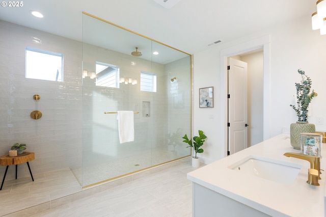 full bathroom with visible vents, a walk in shower, double vanity, recessed lighting, and a sink