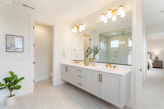 ensuite bathroom with visible vents, double vanity, a sink, a shower stall, and toilet