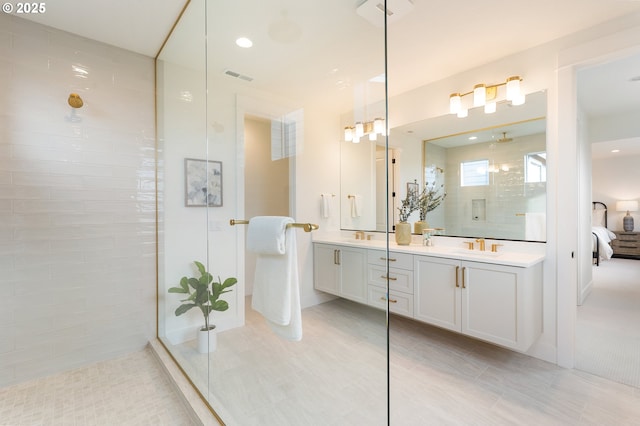 ensuite bathroom featuring visible vents, double vanity, a sink, a walk in shower, and connected bathroom