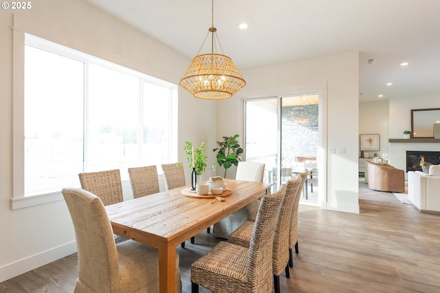 dining area with an inviting chandelier, a healthy amount of sunlight, and light wood-type flooring