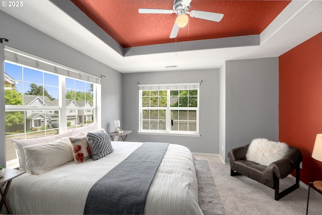 6073 SW 205th Ave, Beaverton, OR 97078 - carpeted bedroom featuring a raised ceiling, multiple windows, ceiling fan, and baseboards