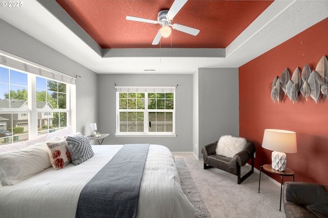 6073 SW 205th Ave, Beaverton, OR 97078 - carpeted bedroom featuring a tray ceiling, multiple windows, baseboards, and a ceiling fan