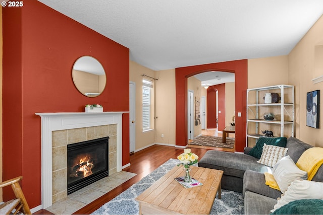 6073 SW 205th Ave, Beaverton, OR 97078 - living area with wood finished floors, arched walkways, a tile fireplace, and baseboards