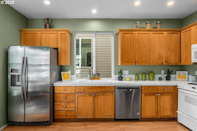 6073 SW 205th Ave, Beaverton, OR 97078 - kitchen featuring stainless steel appliances, a sink, light wood finished floors, brown cabinetry, and recessed lighting