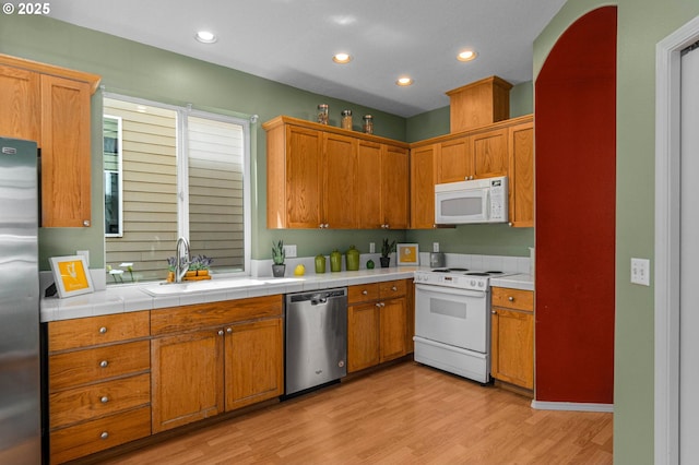 6073 SW 205th Ave, Beaverton, OR 97078 - kitchen with stainless steel appliances, a sink, light wood-type flooring, recessed lighting, and brown cabinetry