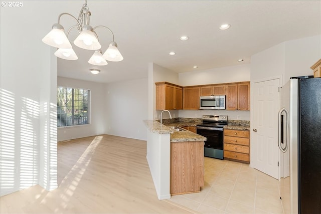 kitchen featuring sink, hanging light fixtures, kitchen peninsula, stainless steel appliances, and light stone countertops