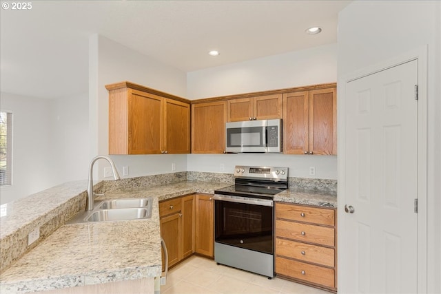 kitchen with light tile patterned flooring, stainless steel appliances, kitchen peninsula, and sink