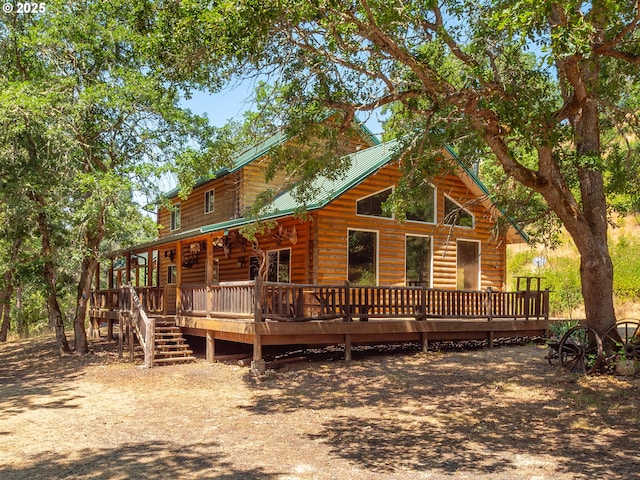 back of property featuring a deck and metal roof