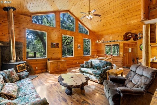 1470 E Willis Creek Rd, Winston, OR 97496 - living area with a wood stove, high vaulted ceiling, healthy amount of natural light, wood walls, and a ceiling fan