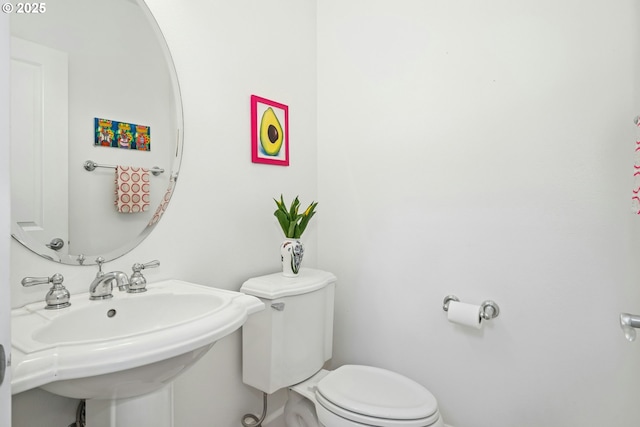 half bathroom featuring toilet and a sink