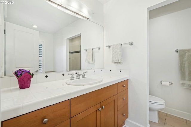 bathroom with toilet, a shower with door, tile patterned flooring, baseboards, and vanity