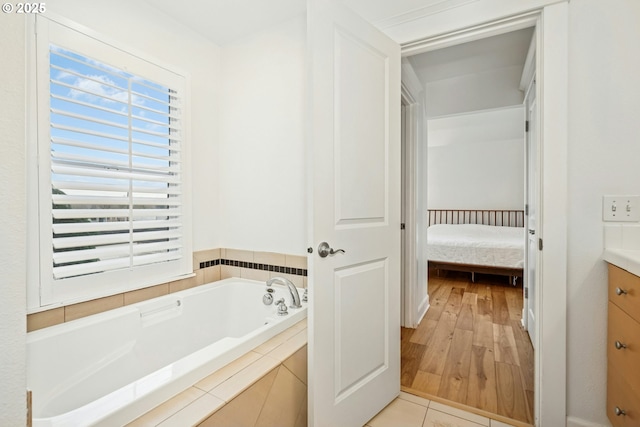 ensuite bathroom featuring vanity, a garden tub, ensuite bath, and tile patterned flooring