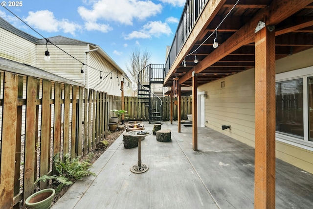 view of patio featuring stairway, an outdoor fire pit, and fence