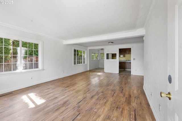 15016 NE Klickitat St, Portland, OR 97230 - unfurnished living room with ornamental molding, plenty of natural light, wood finished floors, baseboards, and beamed ceiling