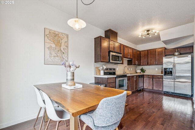 kitchen with baseboards, light countertops, dark wood-style floors, and stainless steel appliances