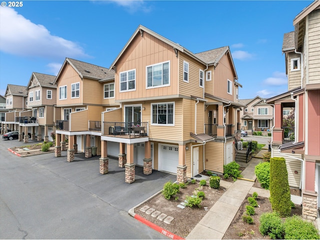 multi unit property with a residential view, board and batten siding, an attached garage, and driveway