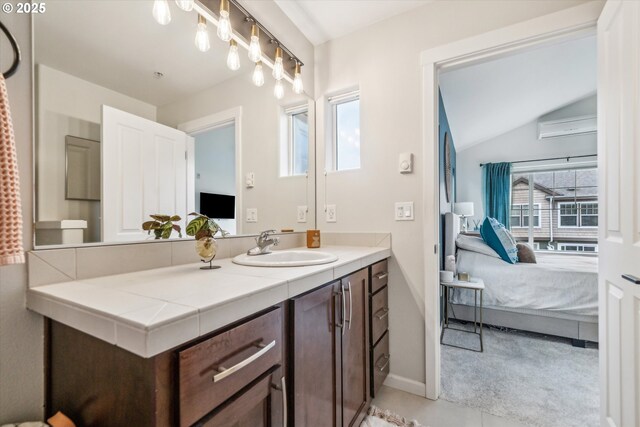 ensuite bathroom featuring tile patterned flooring, vaulted ceiling, vanity, baseboards, and ensuite bathroom