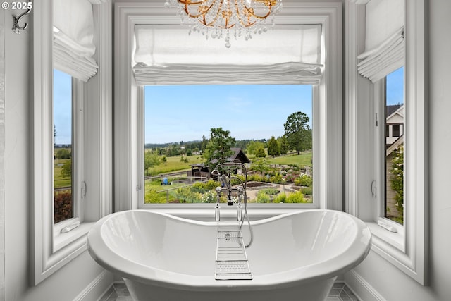 26817 SW Cade Ln, West Linn, OR 97068 - full bathroom featuring a chandelier, baseboards, a freestanding tub, and healthy amount of natural light