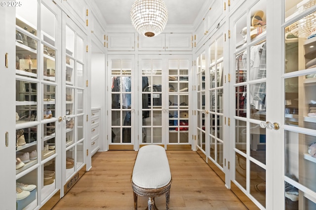 26817 SW Cade Ln, West Linn, OR 97068 - spacious closet with french doors, light wood-style floors, and a chandelier