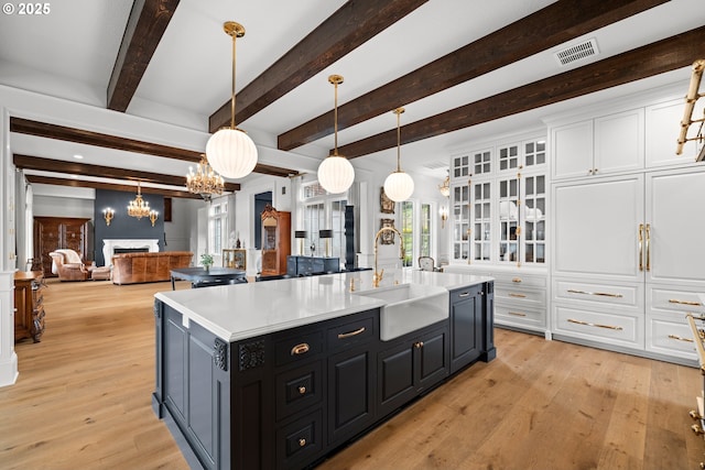 26817 SW Cade Ln, West Linn, OR 97068 - kitchen with a sink, a chandelier, white cabinets, light countertops, and beamed ceiling