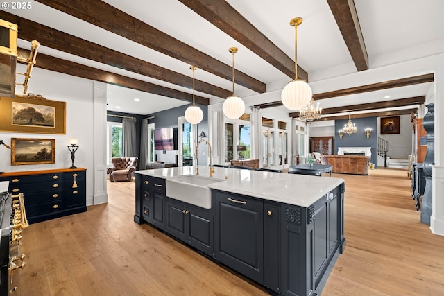 26817 SW Cade Ln, West Linn, OR 97068 - kitchen with a sink, open floor plan, a chandelier, light wood-style floors, and beam ceiling