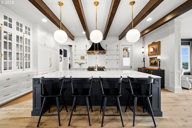 26817 SW Cade Ln, West Linn, OR 97068 - kitchen featuring white cabinetry, light wood-type flooring, light countertops, beamed ceiling, and pendant lighting