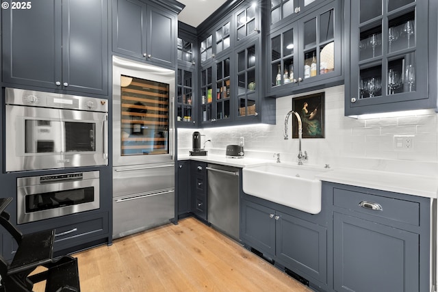26817 SW Cade Ln, West Linn, OR 97068 - kitchen featuring a sink, stainless steel dishwasher, beverage cooler, light wood-style flooring, and backsplash