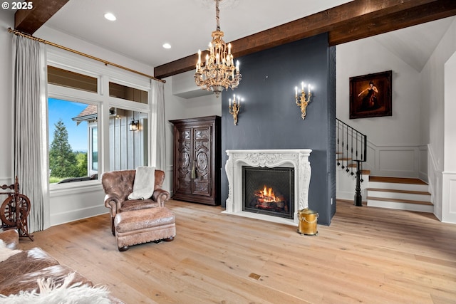 26817 SW Cade Ln, West Linn, OR 97068 - living area with beamed ceiling, stairway, wood finished floors, a chandelier, and a high end fireplace