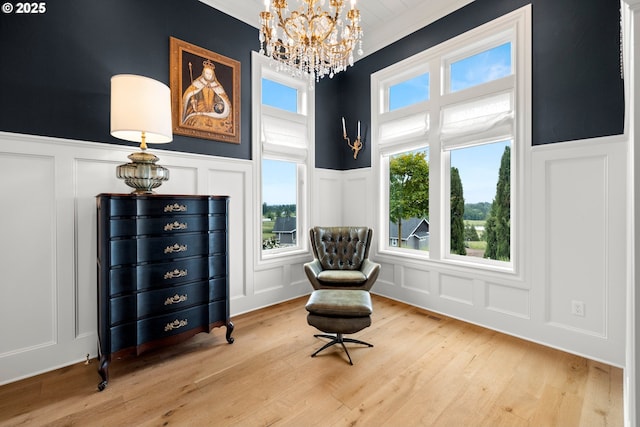 26817 SW Cade Ln, West Linn, OR 97068 - living area featuring a decorative wall, a chandelier, a wainscoted wall, and light wood finished floors