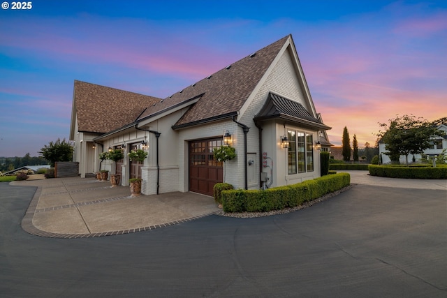 26817 SW Cade Ln, West Linn, OR 97068 - view of side of property with driveway, an attached garage, and roof with shingles