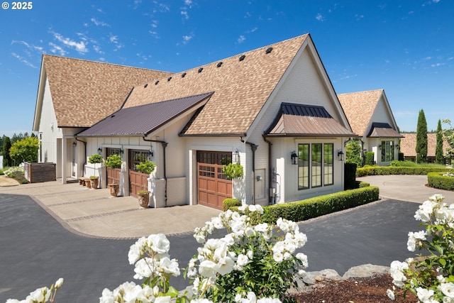 26817 SW Cade Ln, West Linn, OR 97068 - view of front of home with driveway, an attached garage, a standing seam roof, metal roof, and roof with shingles