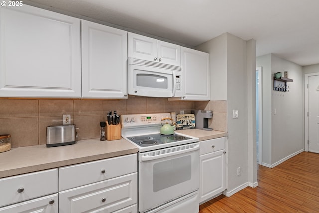 kitchen with decorative backsplash, white appliances, light countertops, and white cabinetry