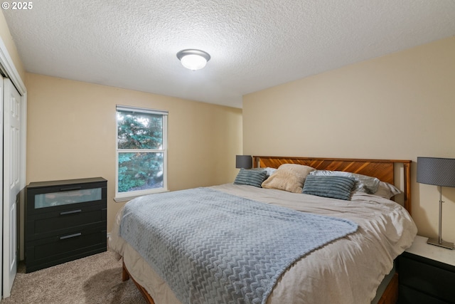 bedroom with a closet, a textured ceiling, and carpet floors