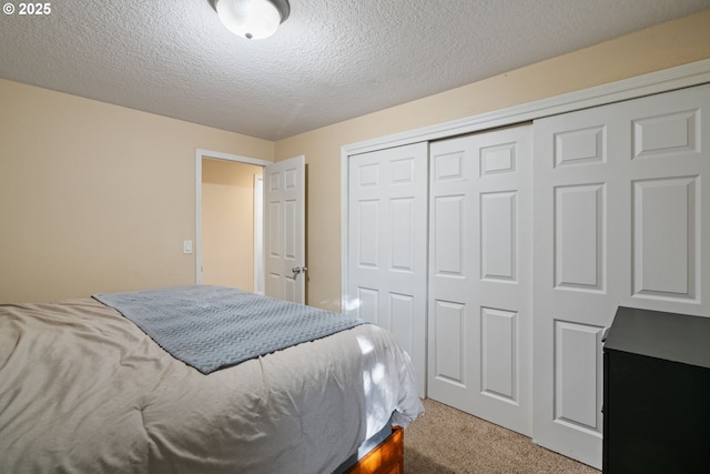 bedroom with a closet, a textured ceiling, and carpet