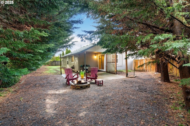 view of yard featuring a patio area, fence, and an outdoor fire pit