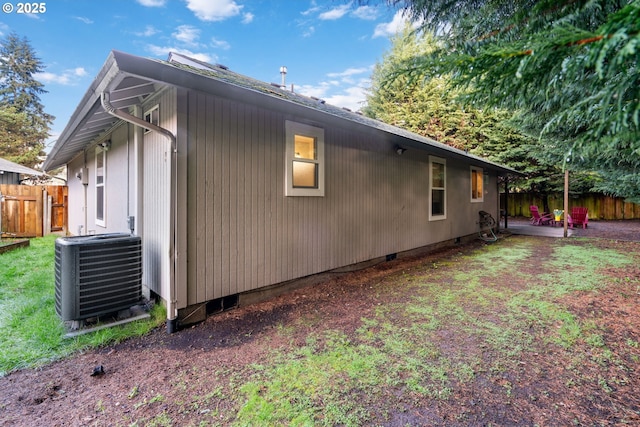 view of property exterior with crawl space, cooling unit, a patio, and fence