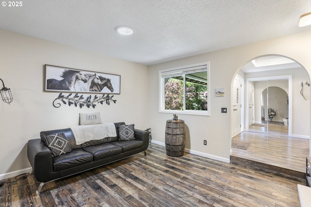 living room with dark wood-type flooring and a textured ceiling