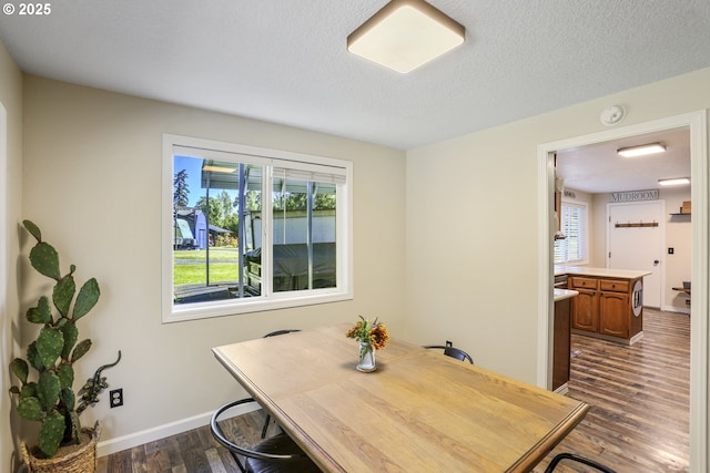 dining room with a healthy amount of sunlight, dark hardwood / wood-style floors, and a textured ceiling