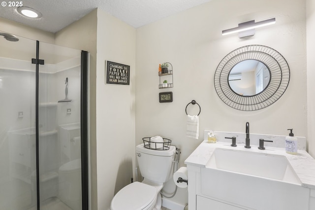 bathroom with vanity, toilet, a textured ceiling, and a shower with shower door