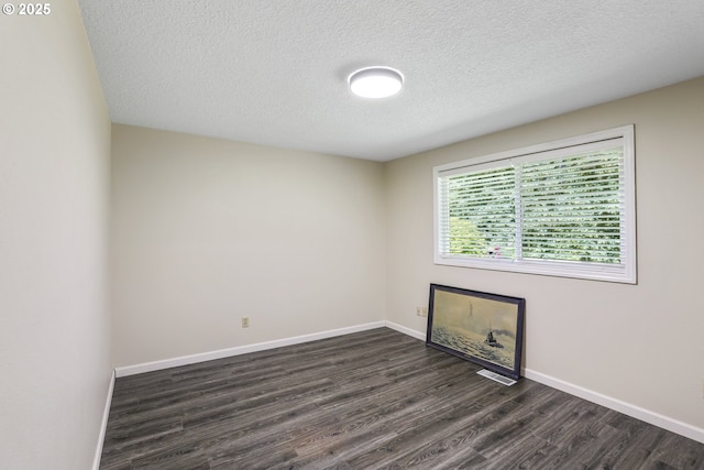 unfurnished room with dark hardwood / wood-style flooring and a textured ceiling