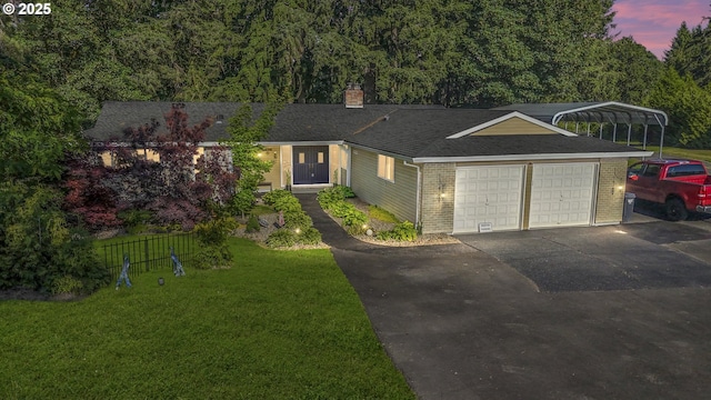 view of front of property featuring a garage, a carport, and a lawn