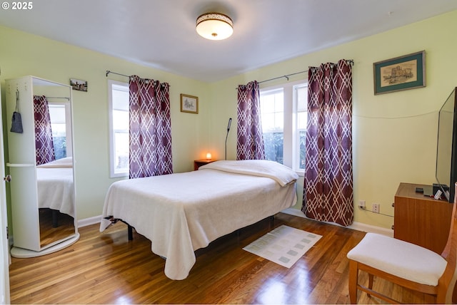 bedroom with baseboards and wood finished floors